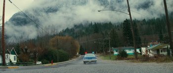 Movie still from “First Blood” (1982), directed by Ted Kotcheff – A car driving down a street near a street light; Extreme Wide shot, High angle