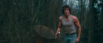 Movie still from “First Blood” (1982), directed by Ted Kotcheff – A man holding a flashlight in the woods; Medium shot, Low angle