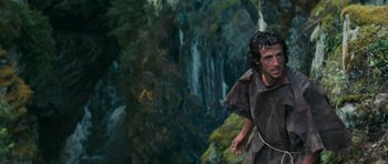Movie still from “First Blood” (1982), directed by Ted Kotcheff – A man is running through the forest near a waterfall; Medium shot, Low angle