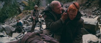 Movie still from “First Blood” (1982), directed by Ted Kotcheff – A man is shaving another man's beard while another man stands in the background; Medium shot, Over the shoulder angle
