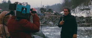 Movie still from “First Blood” (1982), directed by Ted Kotcheff – A man is holding a microphone while another man is standing in the water; Medium shot, Over the shoulder angle