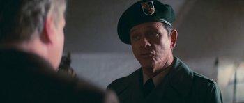 Movie still from “First Blood” (1982), directed by Ted Kotcheff – A man in a military uniform wearing a green hat; Close Up shot, Over the shoulder angle