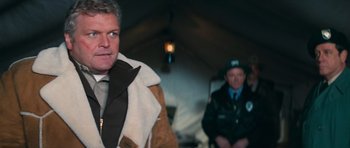 Movie still from “First Blood” (1982), directed by Ted Kotcheff – A man wearing a jacket and tie standing next to another man wearing a jacket and tie; Close Up shot, Over the shoulder angle