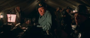 Movie still from “First Blood” (1982), directed by Ted Kotcheff – An older man in a military uniform holding a microphone; Medium shot, Low angle