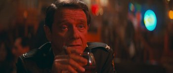 Movie still from “First Blood” (1982), directed by Ted Kotcheff – A person holding a drink in a glass; Close Up shot, Over the shoulder angle