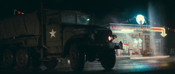 Movie still from “First Blood” (1982), directed by Ted Kotcheff – An old military truck driving down a street at night; Wide shot, Low angle