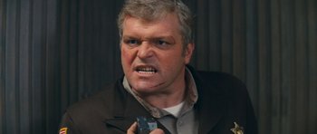 Movie still from “First Blood” (1982), directed by Ted Kotcheff – An older man with gray hair holding a cell phone; Close Up shot, Low angle