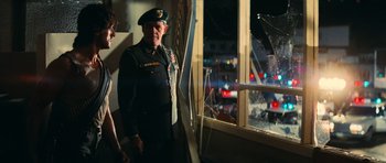 Movie still from “First Blood” (1982), directed by Ted Kotcheff – A man in a uniform standing next to a window; Medium shot, Over the shoulder angle