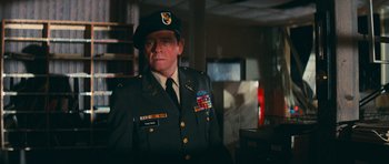 Movie still from “First Blood” (1982), directed by Ted Kotcheff – A man in a military uniform standing in a room; Medium shot, Over the shoulder angle
