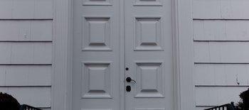 Movie still from “First Reformed” (2017), directed by Paul Schrader – A white door with two panels and a lock on it; Extreme Close Up shot, Low angle