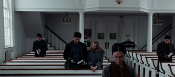 Movie still from “First Reformed” (2017), directed by Paul Schrader – A man and a woman are sitting on the steps of a church; Medium shot, Over the shoulder angle