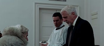 Movie still from “First Reformed” (2017), directed by Paul Schrader – Two men standing next to each other in front of a door; Medium shot, Low angle