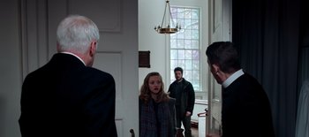 Movie still from “First Reformed” (2017), directed by Paul Schrader – A group of people standing in a room; Medium shot, Over the shoulder angle