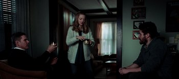 Movie still from “First Reformed” (2017), directed by Paul Schrader – A woman standing in a living room holding a candle; Medium shot, Over the shoulder angle