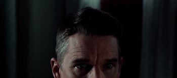 Movie still from “First Reformed” (2017), directed by Paul Schrader – A man's head with a serious look on his face; Extreme Close Up shot, Low angle