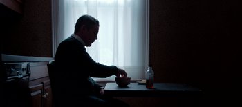 Movie still from “First Reformed” (2017), directed by Paul Schrader – A man sitting at a table with a bowl of food; Medium shot, High angle