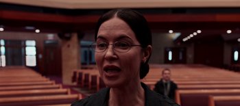 Movie still from “First Reformed” (2017), directed by Paul Schrader – A woman wearing glasses and a black jacket; Close Up shot, Over the shoulder angle