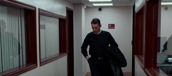 Movie still from “First Reformed” (2017), directed by Paul Schrader – A man standing in a hallway holding a jacket; Medium shot, Low angle