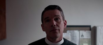 Movie still from “First Reformed” (2017), directed by Paul Schrader – A person wearing a priest's collar; Close Up shot, Low angle