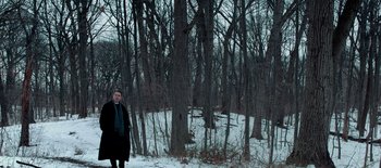 Movie still from “First Reformed” (2017), directed by Paul Schrader – A woman standing in a wooded area in the snow; Extreme Wide shot, High angle