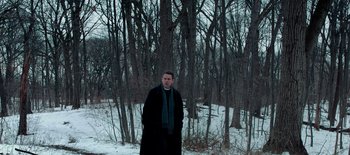 Movie still from “First Reformed” (2017), directed by Paul Schrader – A man standing in the middle of a snowy forest; Wide shot, High angle