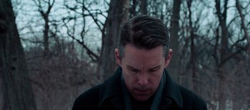 Movie still from “First Reformed” (2017), directed by Paul Schrader – A person wearing a jacket near a tree; Close Up shot, Low angle