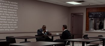 Movie still from “First Reformed” (2017), directed by Paul Schrader – Two businessmen sitting at a table having a conversation; Wide shot, Over the shoulder angle