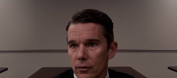 Movie still from “First Reformed” (2017), directed by Paul Schrader – A person wearing a suit and tie; Close Up shot, High angle