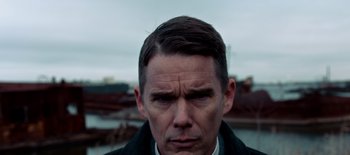 Movie still from “First Reformed” (2017), directed by Paul Schrader – A person wearing a suit and tie; Close Up shot, Low angle