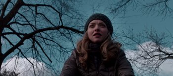Movie still from “First Reformed” (2017), directed by Paul Schrader – A woman in a winter coat and a hat looking up at the sky; Close Up shot, Low angle