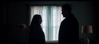 Movie still from “First Reformed” (2017), directed by Paul Schrader – A man and a woman standing next to each other in front of a window; Medium shot, Low angle