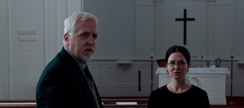 Movie still from “First Reformed” (2017), directed by Paul Schrader – A man and a woman standing next to each other in a church; Medium shot, Over the shoulder angle