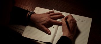 Movie still from “First Reformed” (2017), directed by Paul Schrader – A person writing in a notebook with a pen; Extreme Close Up shot, High angle