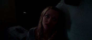 Movie still from “First Reformed” (2017), directed by Paul Schrader – A woman is looking at the camera with a dark background; Close Up shot, High angle