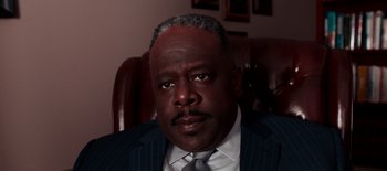 Movie still from “First Reformed” (2017), directed by Paul Schrader – A person wearing a suit and tie; Close Up shot, High angle