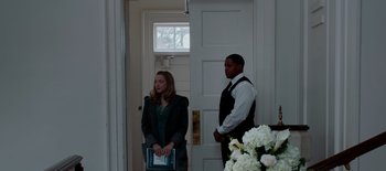 Movie still from “First Reformed” (2017), directed by Paul Schrader – A man and a woman standing in front of a white door; Medium shot, Over the shoulder angle