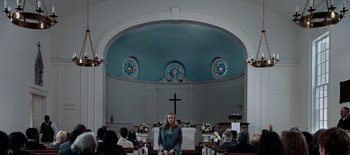 Movie still from “First Reformed” (2017), directed by Paul Schrader – A woman standing in front of a cross in a church; Wide shot, Low angle