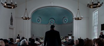 Movie still from “First Reformed” (2017), directed by Paul Schrader – A man standing in front of a group of people in a church; Wide shot, Low angle