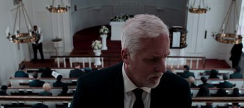 Movie still from “First Reformed” (2017), directed by Paul Schrader – An older man wearing a suit and tie in a church; Close Up shot, Low angle