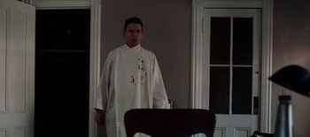 Movie still from “First Reformed” (2017), directed by Paul Schrader – A man in a white robe standing in front of a chair; Medium shot, Low angle