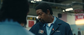 Movie still from “Flamin' Hot” (2023), directed by Eva Longoria – A man in a blue jacket is listening to music; Close Up shot, Over the shoulder angle