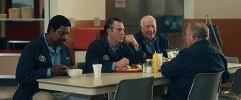 Movie still from “Flamin' Hot” (2023), directed by Eva Longoria – A group of men sitting at a table eating food; Medium shot, Over the shoulder angle