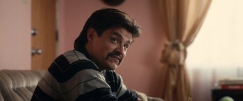 Movie still from “Flamin' Hot” (2023), directed by Eva Longoria – A person sitting on a couch; Close Up shot, Over the shoulder angle