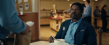Movie still from “Flamin' Hot” (2023), directed by Eva Longoria – A man sitting at a table with a bowl of food; Medium shot, Over the shoulder angle