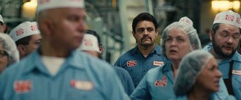 Movie still from “Flamin' Hot” (2023), directed by Eva Longoria – A group of men standing next to each other in a factory; Close Up shot, Over the shoulder angle
