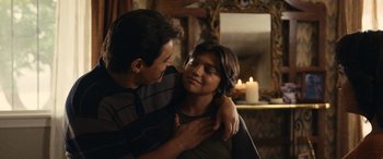 Movie still from “Flamin' Hot” (2023), directed by Eva Longoria – A man and a woman hugging in front of a mirror; Medium shot, Over the shoulder angle