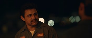 Movie still from “Flamin' Hot” (2023), directed by Eva Longoria – A man with a mustache wearing a brown jacket; Close Up shot, Over the shoulder angle