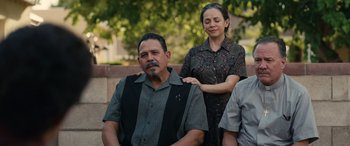 Movie still from “Flamin' Hot” (2023), directed by Eva Longoria – A man sitting next to a woman on a bench; Medium shot, Over the shoulder angle