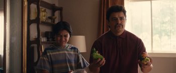 Movie still from “Flamin' Hot” (2023), directed by Eva Longoria – A man and a woman standing next to each other holding food; Close Up shot, Over the shoulder angle