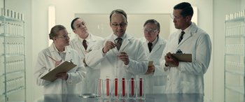 Movie still from “Flamin' Hot” (2023), directed by Eva Longoria – A group of men in lab coats working in a lab; Medium shot, Low angle